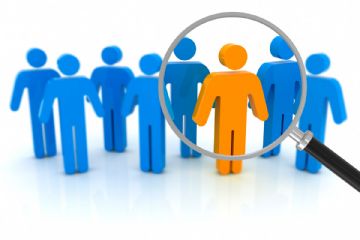 Nell'immagine sono raffigurate otto manichini simili che rappresentano persone, sette sono di colore blu, uno di colore arancione che è evidenziato con una lente di ingrandimento.