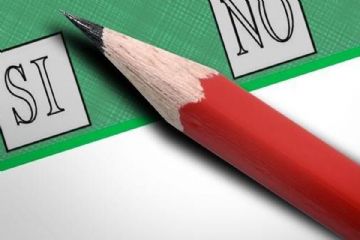 Scheda elettorale di colore verde a sinistra casella con la scritta SI a destra casella con scritta NO nel mezzo alle casella cè una matita